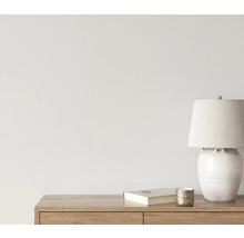 Dekorative Szene mit Tischleuchte, Buch und Kerzenhalter auf einem Holzmöbel