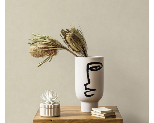 Scène décorative avec vase avec impression de visage, fleurs séchées, boîte à bijoux et livres sur une table en bois