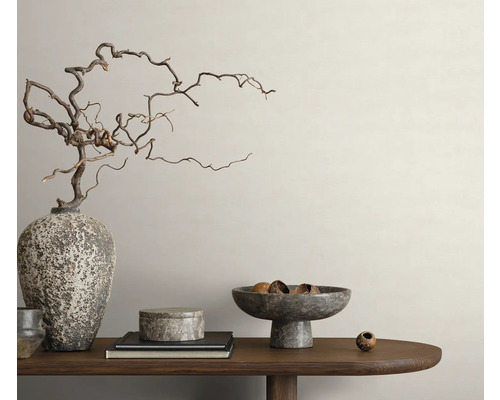 Dekorative Anordnung mit Vase, Ästen, Schalen und Büchern auf einem Holztisch