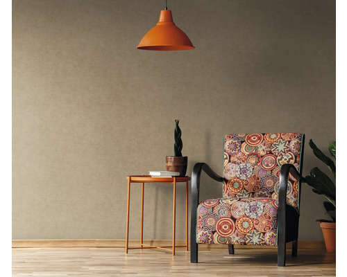 Dekorativer Wohnraum mit gemusterter Tapete, Sessel, Tisch und Lampe