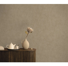 Dekoratives Interieur mit Blumenvase und Teekanne auf einem Holzschrank vor einer strukturierten Wand