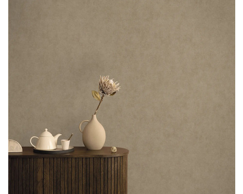 Dekoratives Interieur mit Blumenvase und Teekanne auf einem Holzschrank vor einer strukturierten Wand