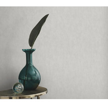 Papier peint décoratif avec un vase vert, une feuille et une sphère sur une table