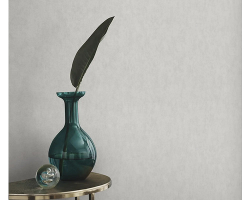 Papier peint décoratif avec un vase vert, une feuille et une sphère sur une table
