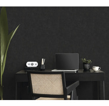 Espace de travail avec bureau, chaise, ordinateur portable et décoration devant un mur sombre