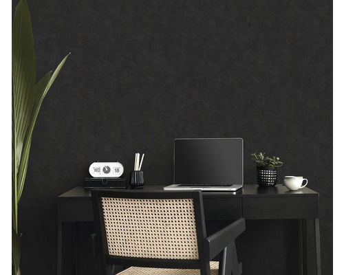 Espace de travail avec bureau, chaise, ordinateur portable et décoration devant un mur sombre