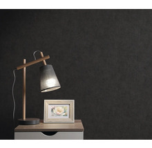 Table de chevet avec lampe et cadre photo devant un mur sombre