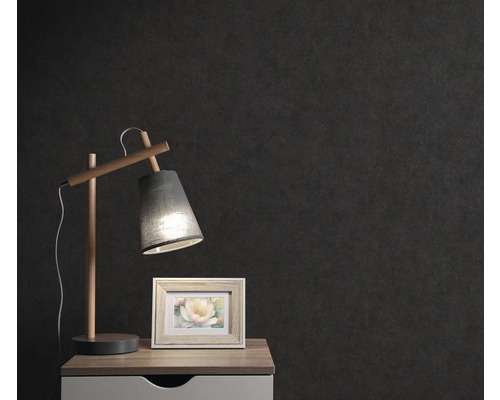 Table de chevet avec lampe et cadre photo devant un mur sombre