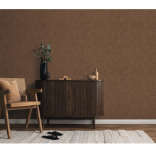 Wohnzimmer mit brauner Wandtapete, Holzstuhl, Schrank und Teppich für eine gemütliche Atmosphäre