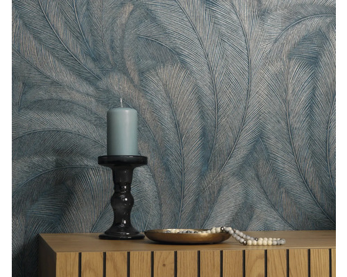 Mur décoratif avec papier peint à plumes, bougie et bijoux sur commode