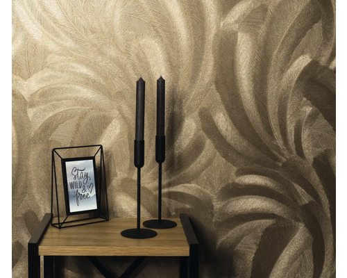 Gros plan d'un mur avec un motif de papier peint à plumes, un chandelier et un cadre photo sur une table en bois