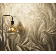 Gros plan d'un papier peint à motif de plumes à côté d'un lampadaire avec une ampoule dans une boule de verre