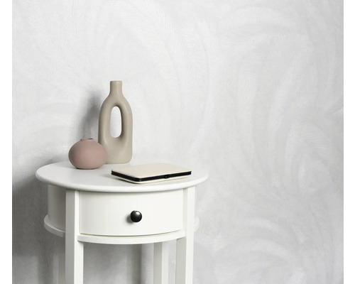 Papier peint clair à motifs derrière une table de chevet blanche avec décoration