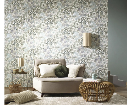 Wohnraum mit floral gemusterter Tapete, Sessel und Beistelltischen