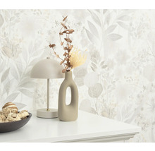 Scène décorative avec papier peint floral, lampe, vase et bol sur une commode