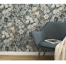 Nahaufnahme einer Wandtapete mit Blumenmuster hinter einem Sessel in einem Raum