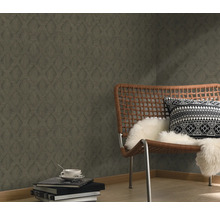 Raumansicht mit gemusterter Tapete, Sessel und Dekoration