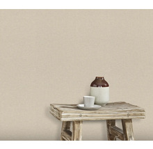 Mur avec papier peint textile, sur lequel se trouvent un tabouret avec un vase et une tasse