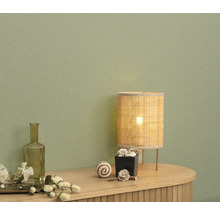 Intérieur décoratif avec lampe de table et accessoires sur une commode devant un mur.