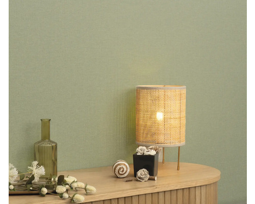 Intérieur décoratif avec lampe de table et accessoires sur une commode devant un mur.