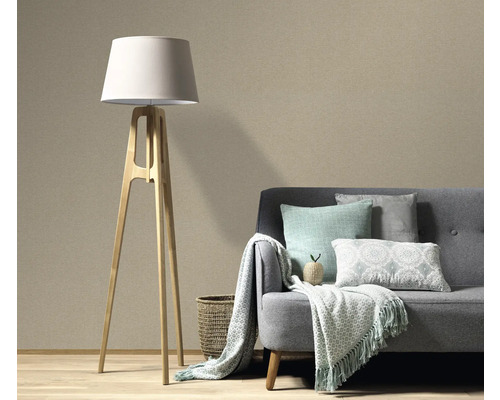 Salon avec lampadaire et canapé devant un papier peint structuré