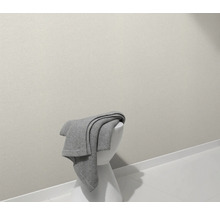 Ein grauer Überwurf liegt auf einem weißen Hocker