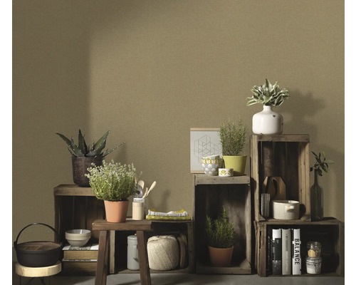 Dekorative Holzkisten mit Pflanzen, Büchern und Küchenutensilien aufgestellt vor einer einfarbigen Wand.