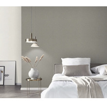 Chambre avec lit, table de chevet, lampe et papier peint gris