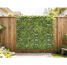 Dekoratives grünes Paneel mit weißen Blüten an einem Holzzaun