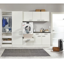 Buanderie lumineuse avec machine à laver, armoires et étagères pour produits de lessive et linge