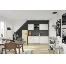 Cuisine lumineuse avec coin repas, équipée d'armoires de cuisine, d'une table à manger, de chaises et d'un réfrigérateur rétro.