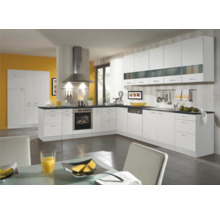 Cuisine lumineuse avec armoires blanches, hotte et appareils électroménagers.