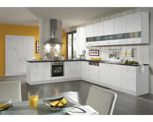 Cuisine lumineuse avec armoires blanches, hotte et appareils électroménagers.