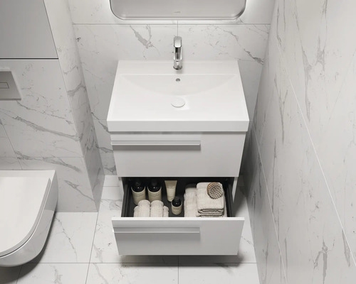 Salle de bains moderne avec meuble sous-lavabo et tiroir ouvert contenant des articles de toilette.