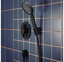 Ensemble de douche avec douchette à main et thermostat sur un mur carrelé