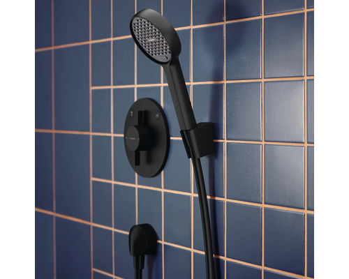 Ensemble de douche avec douchette à main et thermostat sur un mur carrelé