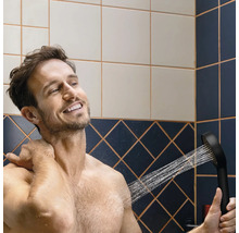 Un homme utilise une douchette dans la salle de bain