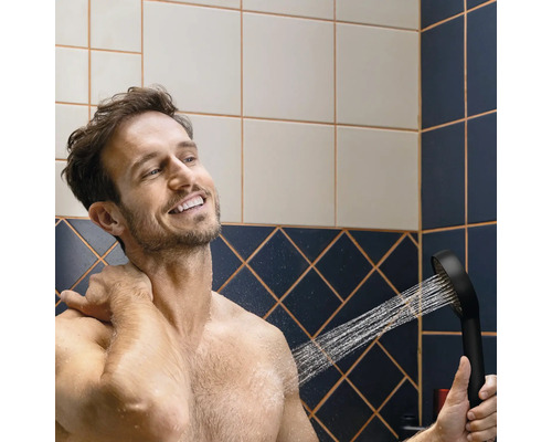 Un homme utilise une douchette dans la salle de bain