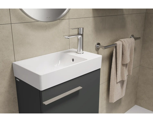Meuble-lavabo avec lavabo, robinet et porte-serviettes dans la salle de bain