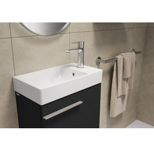 Lavabo avec robinet, serviette et porte-serviettes dans la salle de bain