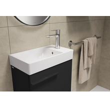Lavabo avec robinet, serviette et porte-serviettes dans la salle de bain