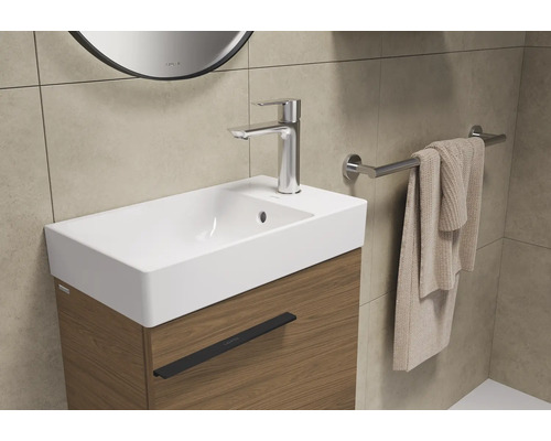 Vasque avec robinet, serviette et porte-serviettes dans la salle de bain