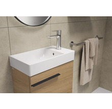 Meuble sous-lavabo avec robinet, serviette et porte-serviettes dans la salle de bain