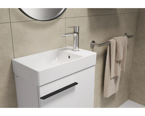 Lavabo avec robinet, serviette et porte-serviettes dans la salle de bain