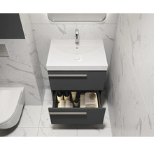 Meuble-lavabo de salle de bains avec tiroir ouvert, lavabo, robinet et articles de toilette