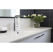 Waschtisch mit Armatur und weißen Lilien in Vase