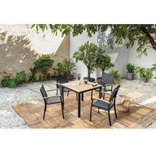 Quadratischer Gartentisch mit vier Stühlen auf Holzboden in einem Garten.
