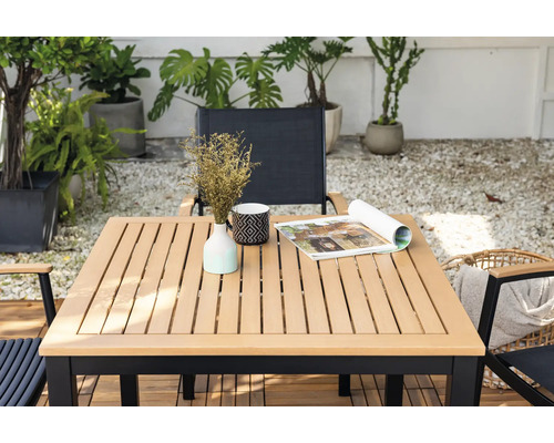 Quadratischer Gartentisch mit Dekoration und Stühlen im Außenbereich.