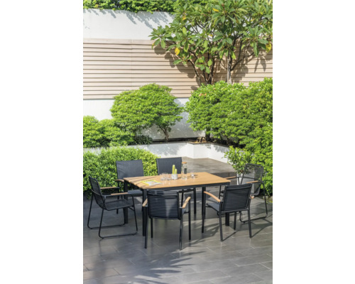 Gartenszene mit einem Esstisch und Stühlen umgeben von üppigem Grün
