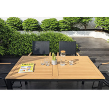 Gartenszene mit Esstisch, Stühlen, Gläsern, Wasserkaraffe, Zeitschrift und Kaktus